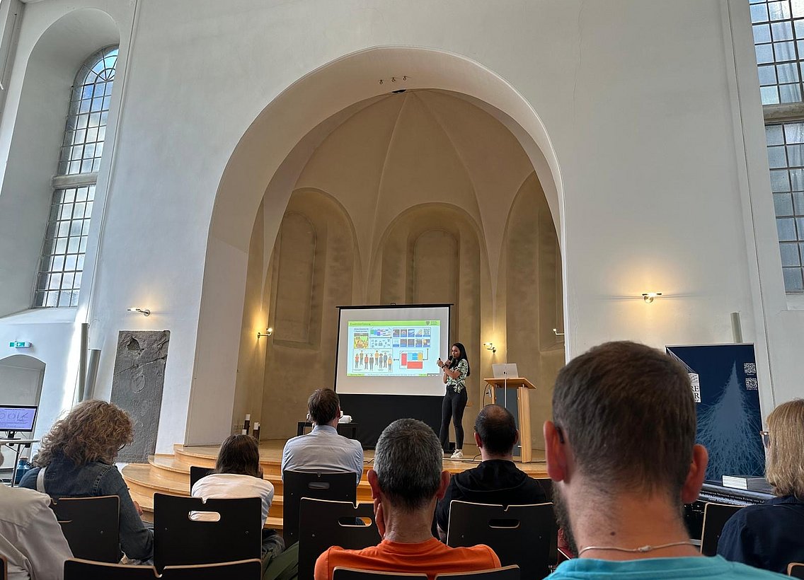 Eine Doktorandin hält einen Vortrag vor Publikum.